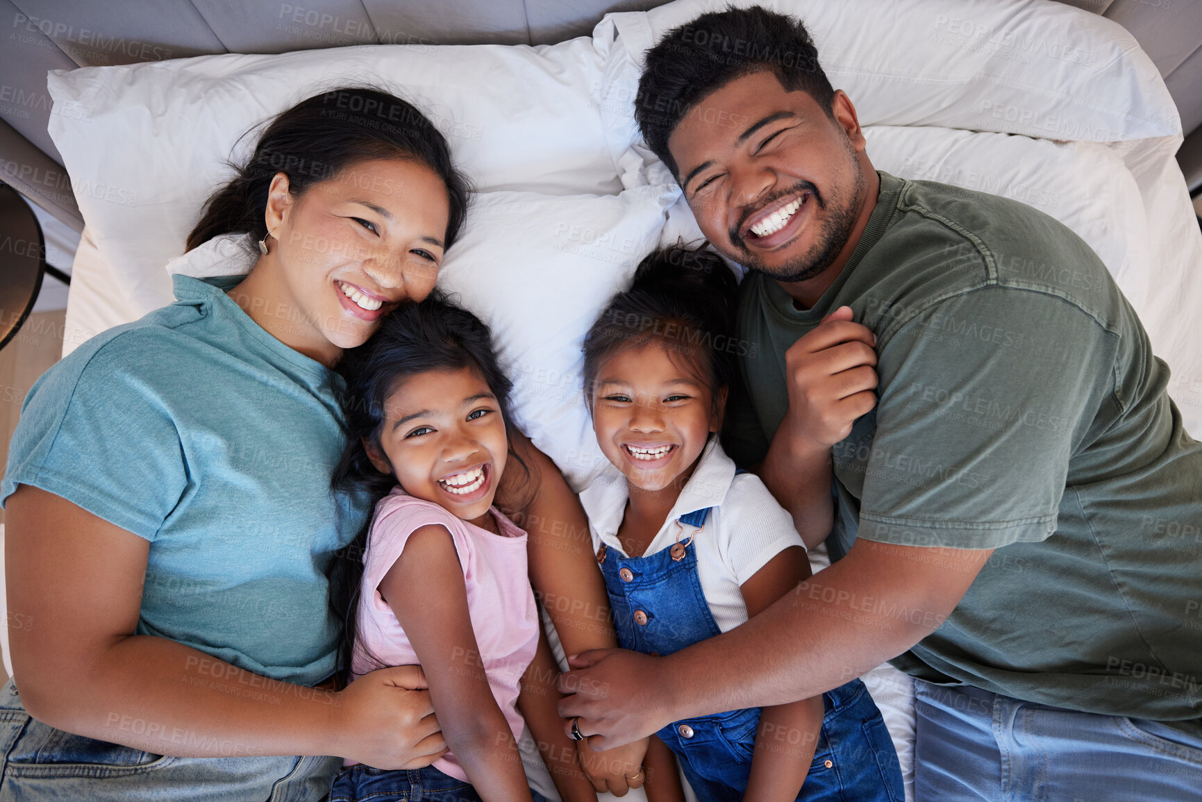Buy stock photo A happy black family in bed, mom and dad hold children with love. In their bedroom at home, little kids laugh as parents hug them with a smile on their faces and enjoy the quality time home together 