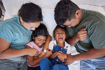 Buy stock photo Family, children and love above parents ticking a girl and her sister in the bed in a bedroom of the home together. Happy, smile and laugh with a mother and father tickling their daughters from above