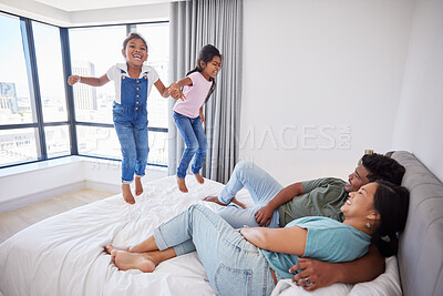 Buy stock photo Relax, happy family and kids jump on bed mattress in Philippines home with parents watching. Young, excited and happy children enjoy leisure fun together with mom and dad in cozy bedroom.