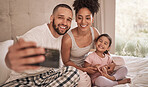 Phone selfie of a relax happy family in bed, bond and enjoy quality time together in home bedroom. Love, morning and happiness for fun couple in pajamas bonding with adopted youth child, kid or girl