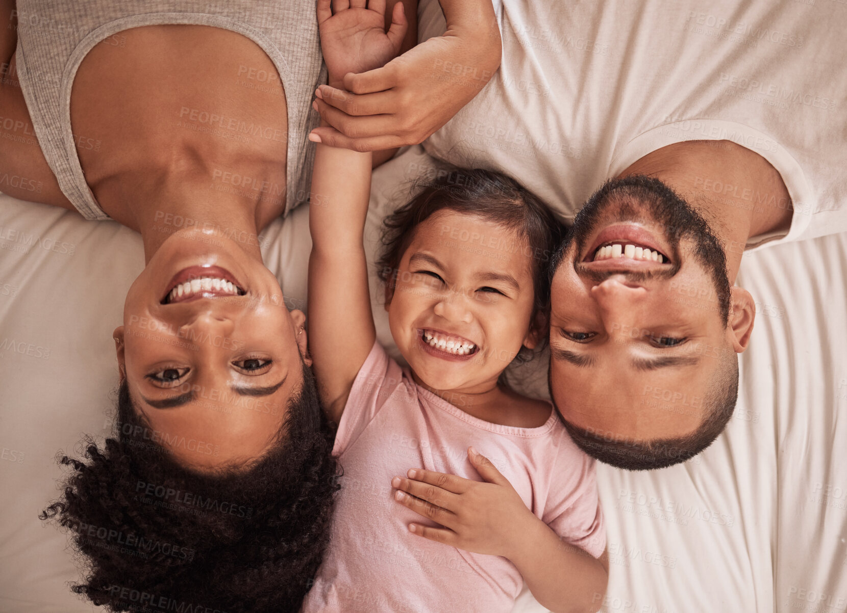 Buy stock photo Relax, happy family and portrait on bed in bedroom home with smile, bonding and happiness from above. Love, comfort and care of caring Brazilian mom, dad and girl spending quality time together.
