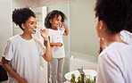 Mirror reflection of mom and girl brushing teeth together while bonding, having fun and enjoy quality time. Child development, learning or dental care for oral hygiene girl cleaning teeth in bathroom