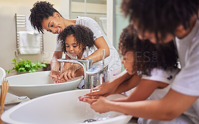 Buy stock photo Mom and child in bathroom washing hands, cleaning and learning hygiene at home. Young mother with girl teaching and helping her to wash hands with soap and water for child development in health