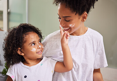 Buy stock photo Happy family, mother and girl with cream skincare on face in the morning to bond in Mexico home. Smiling latino mom with young and cheerful child putting moisturiser on parent in house bathroom.
