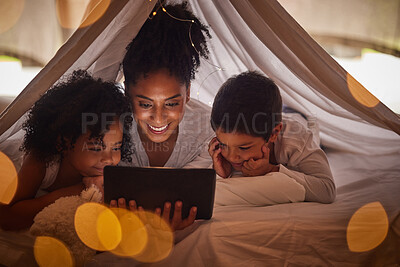 Buy stock photo Family, tablet and online streaming with kids for a bedtime story, movie or cartoon for educational fun while in a blanket fort. Brazilian woman with boy and girl child at night reading on internet