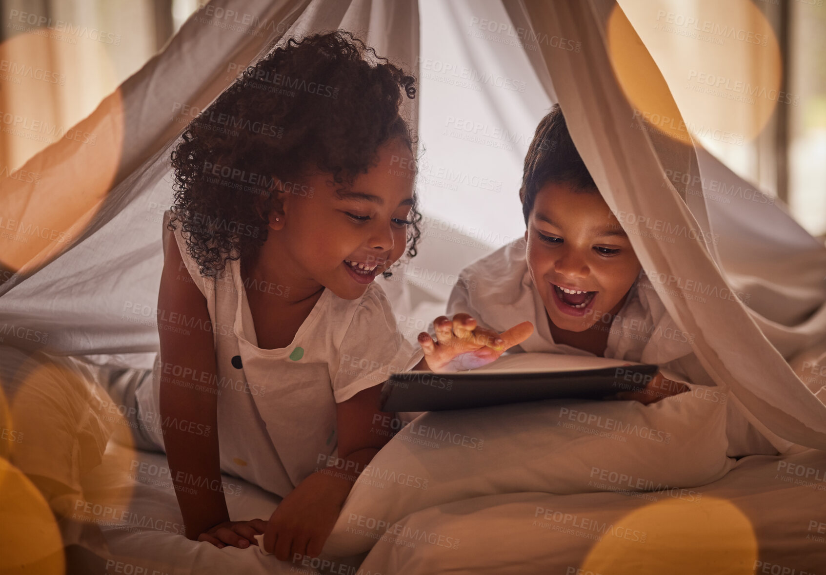 Buy stock photo Children, tablet and night streaming online for movies, cartoon or educational games before bedtime in a blanket fort with a fun app. Excited boy and girl kid sharing, reading and internet addiction