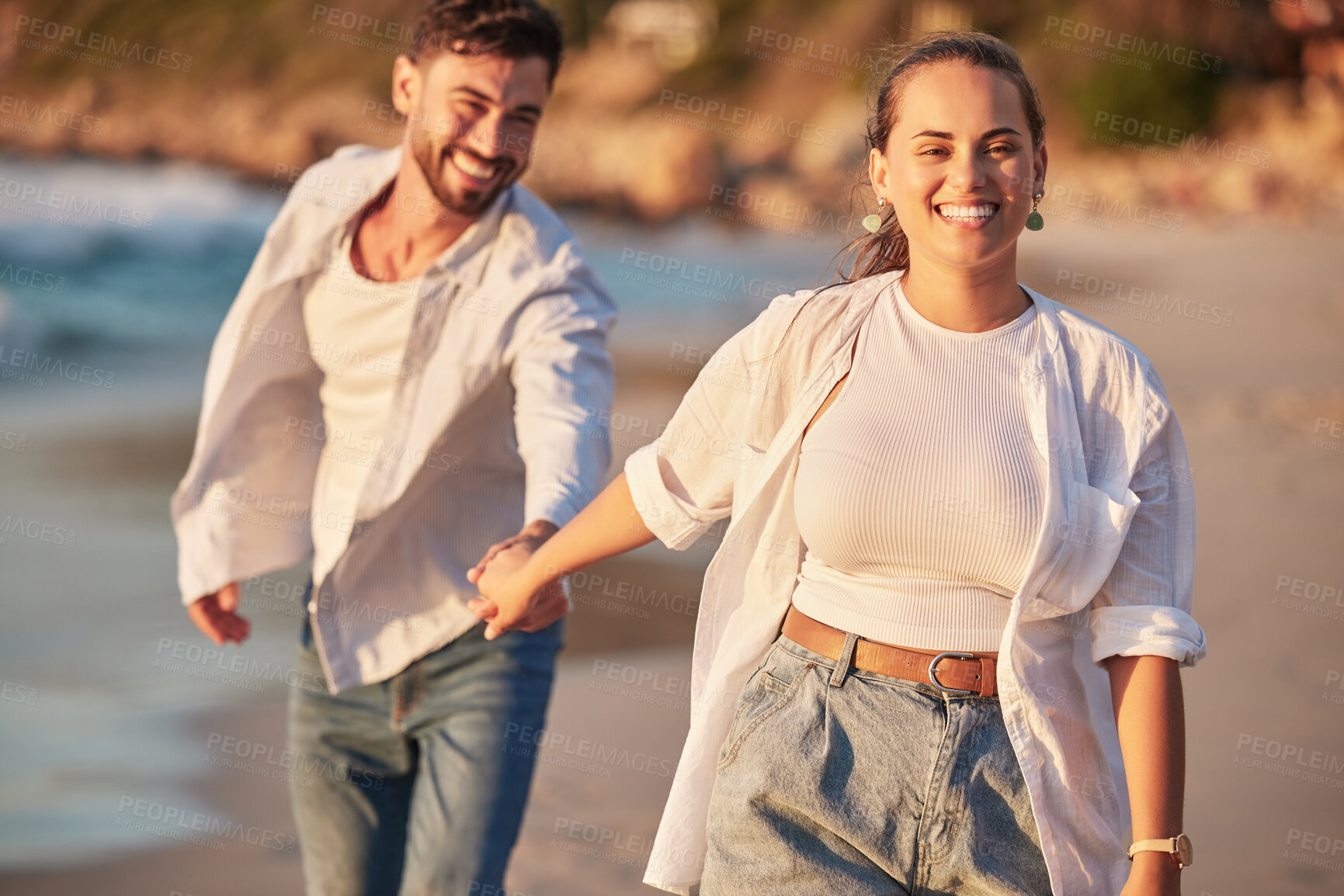 Buy stock photo Happy couple, beach and travel while holding hands, laughing and having fun on Portugal summer vacation or holiday traveling to seaside. Smile of man and woman on honeymoon sharing love and adventure