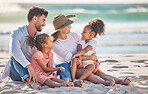Interracial family, beach vacation and travel with children and parents sitting in sand enjoying summer holiday in maldives. Man, woman and girl kids having fun and feeling happy on a tropical trip 