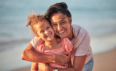 Buy stock photo Portrait of grandmother and child at the beach on holiday, smiling and having fun. Senior woman with grandchild, hugging her by the ocean during sunset. Summer, vacation and family holiday at the sea