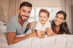 Mother, father and baby boy bonding in house, family home or hotel bedroom with trust, love or security. Couple portrait, smile or happy Brazilian man, woman or parents with playful son, child or kid