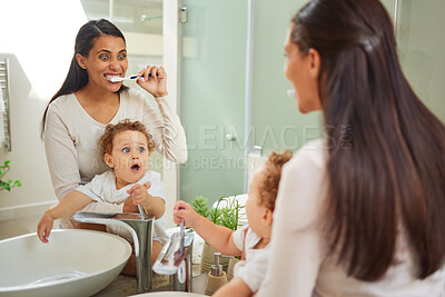 Buy stock photo Dental, teeth and health with a mother and baby brushing teeth in the bathroom of their home together. Children, oral hygiene and healthcare with a woman and her son using a toothbrush in the morning