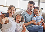 Family selfie, interracial smile and parents with phone for social media with children, happy on the sofa in house and relax with kids in home. Girl siblings taking photo with mother and father