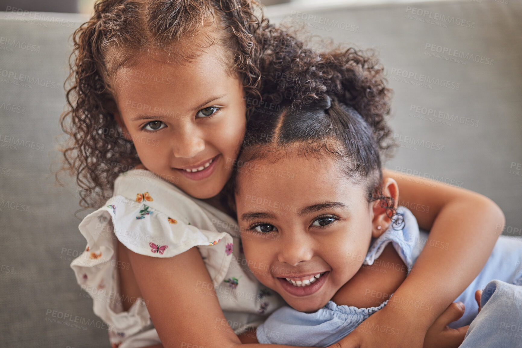 Buy stock photo Happy, smile and portrait of sisters hugging while sitting on a sofa in the living room at the family home. Happiness, love and girl siblings from puerto rico bonding while relaxing on couch together