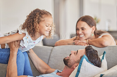 Buy stock photo Family, love and support of dad with child playing lifting plane game while feeling happy on the couch in their costa rica home. Smile, joy and fun with man, woman and girl kid or daughter with trust