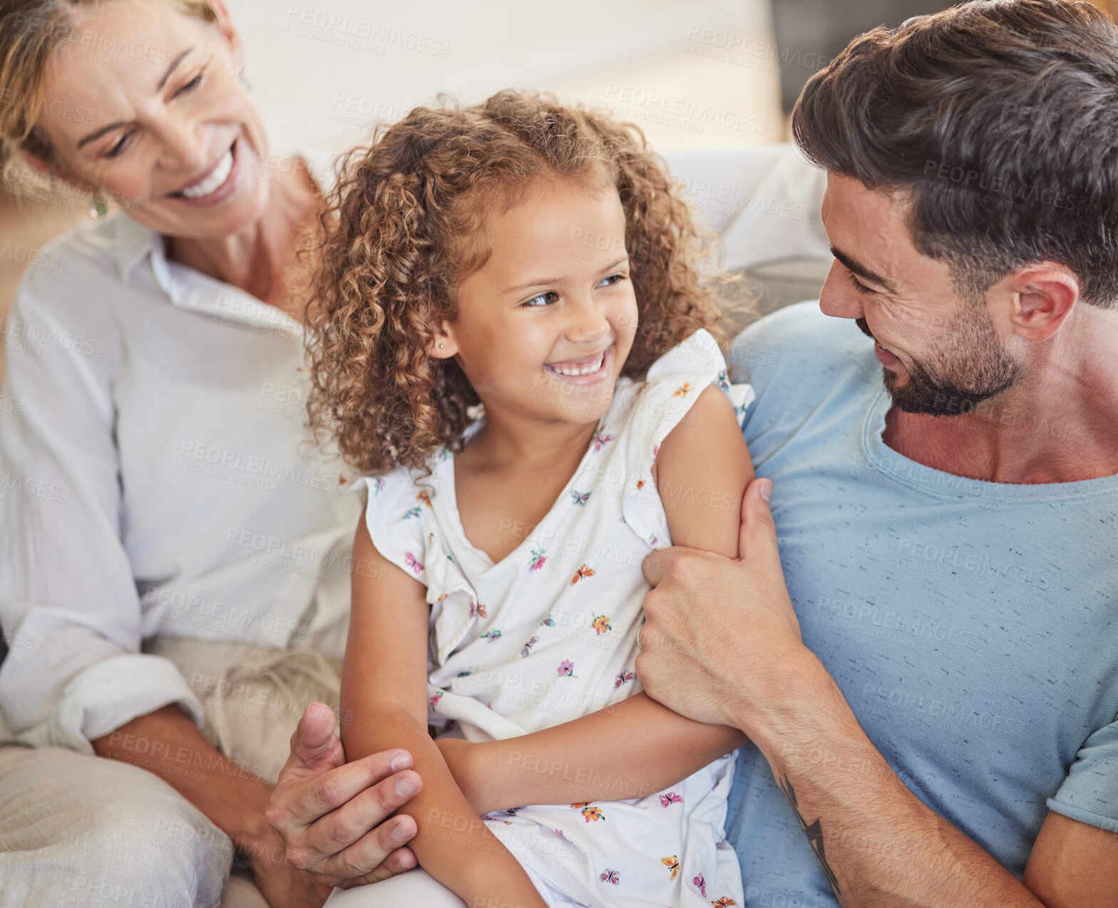 Buy stock photo Happy family on sofa, smile together in living room and funny dad joke in Madrid home apartment. Child laughing at comic white father, parents relax in lounge and hug cute young girl happiness