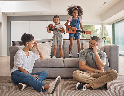 Buy stock photo Stress, family and energy with kids playing music on a guitar in the living room at home while giving mom and dad a headache. Mental health, children and tired with a girl and sister causing chaos
