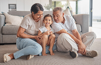 Buy stock photo Grandparents, little girl and love in relaxing bonding time together in the living room at home. Portrait of happy child smiling in loving, fun relationship with grandma and grandpa relaxing on floor