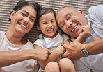 Kid, grandma and grandpa lying on floor at home, spending family time together above view. Happy grandparents babysitting little girl in Mexico. Senior man, elderly woman and child laughing on carpet