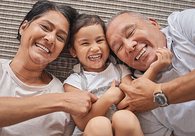Buy stock photo Kid, grandma and grandpa lying on floor playing at home, spending family time together above view. Happy grandparents bonding with little girl in Mexico. Senior man, elderly woman and child laughing.