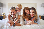 Family, kids and bedroom with a girl, boy and parents lying on a bed in their home together in the morning. Children, happy and smile with a mother, father and siblings enjoying the weekend indoors