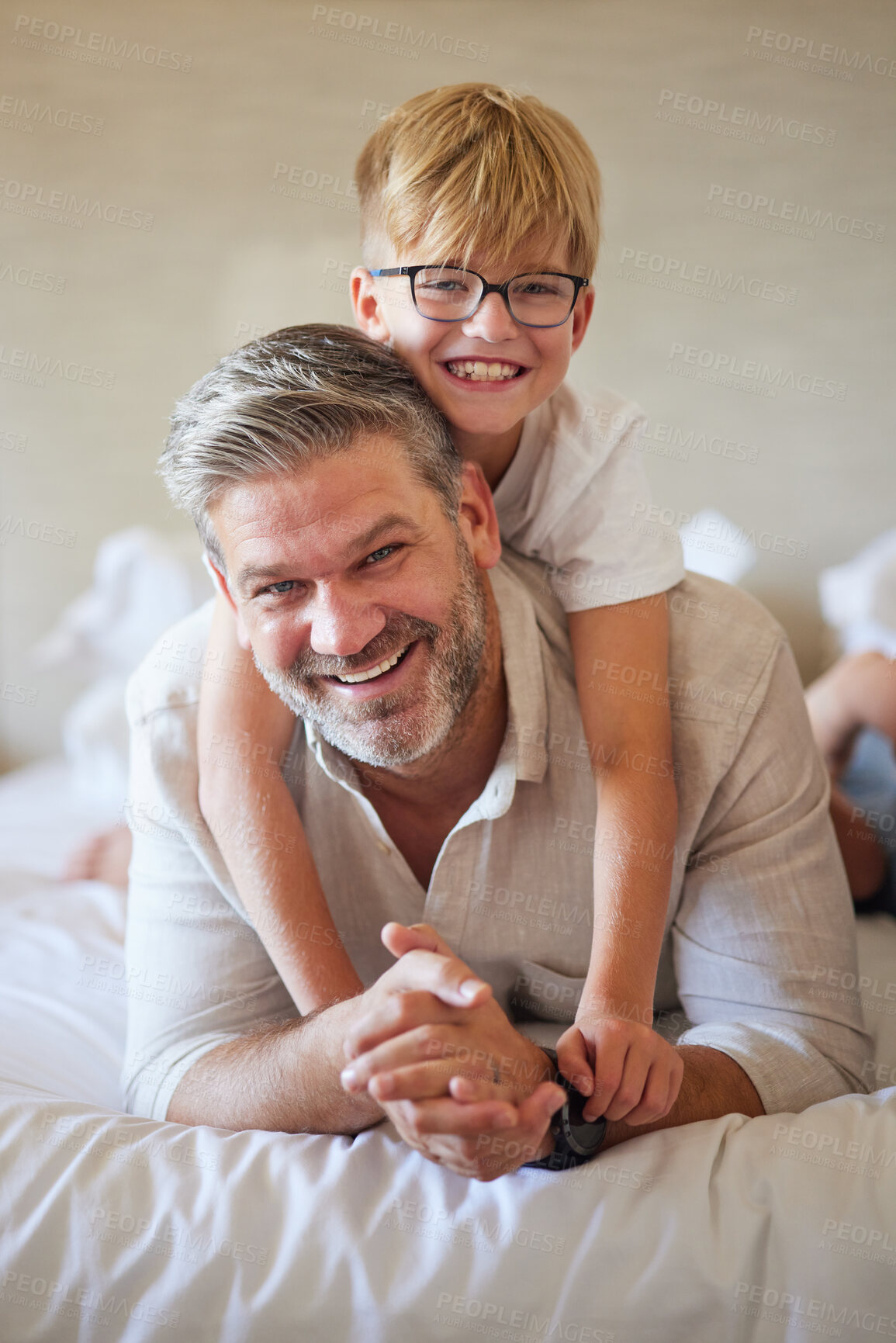 Buy stock photo Family, love and children with a father and son lying on bed together in a bedroom of their home. Face, happy and smile with a portrait of a man and his boy child in their house to relax on a morning