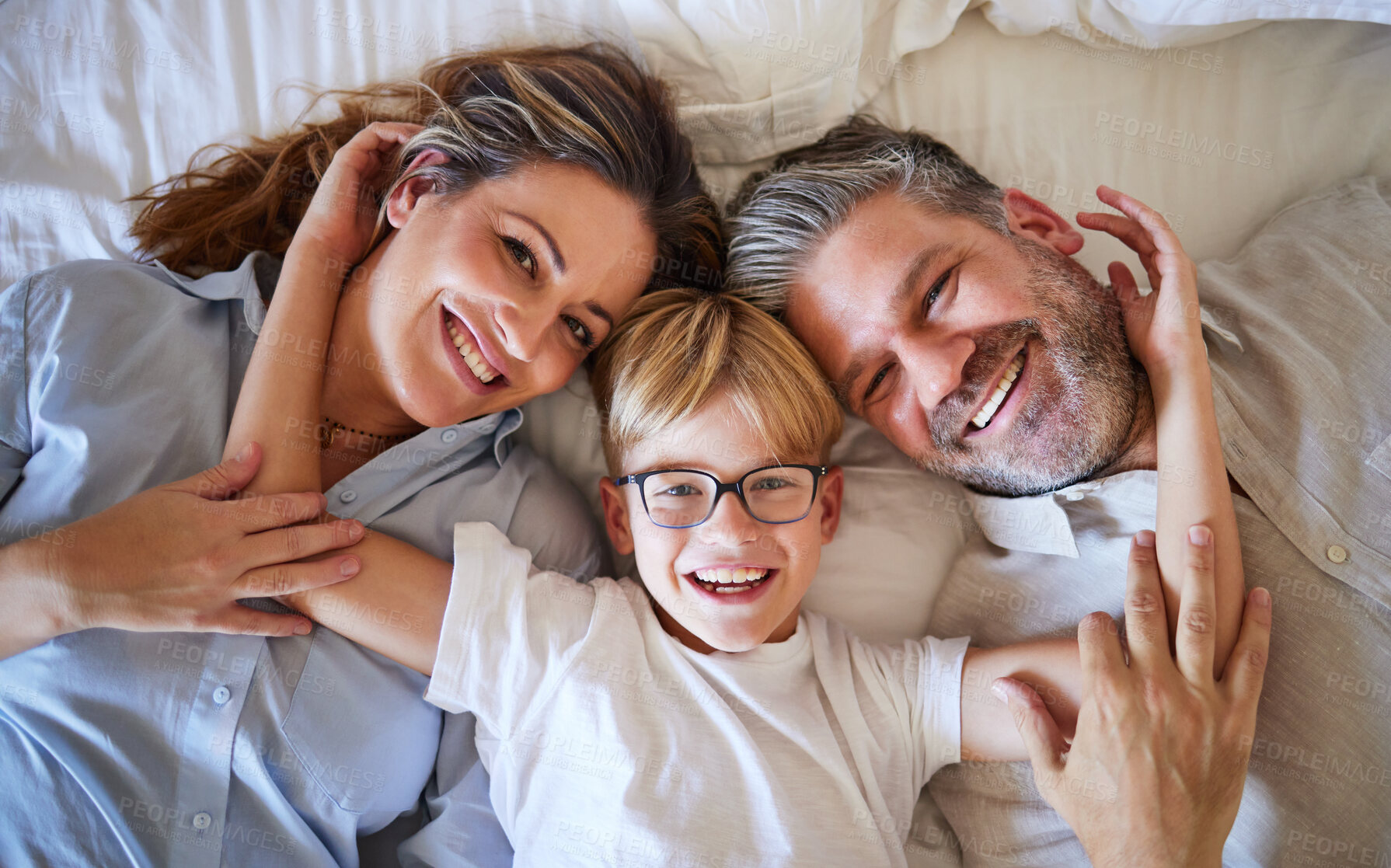 Buy stock photo Portrait of family, kid and parents bedroom for fun morning, relax lifestyle and happiness. Above smile mom, happy dad and playful boy children together in bedroom for love, care and laughing weekend