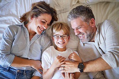 Buy stock photo Family, tickling and child lying on bed with his happy mom and dad laughing and having fun in their bedroom at home. Portrait of boy kid with a man and woman parents to relax in their Australia house