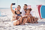 Happy, family and beach selfie with smile together on summer vacation bonding and relaxing on the sand. Mother, father and children relax on sandy shore, holiday break or weekend smiling in happiness