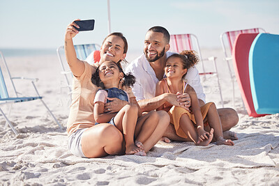Happy, family and beach selfie with smile together on summer vacation bonding and relaxing on the sand. Mother, father and children relax on sandy shore, holiday break or weekend smiling in happiness