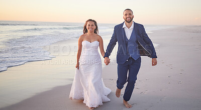 Buy stock photo Wedding, couple and beach with a man and woman holding hands while walking on the sand by the ocean or sea. Love, trust and marriage with a bride and groom on the coast at sunset for celebration