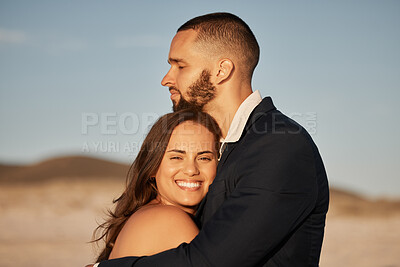 Buy stock photo Wedding, love and happy with couple at sunset and hug together for celebration, event or beach venue. Smile, support and commitment with man and woman holding in embrace for marriage, goals and trust