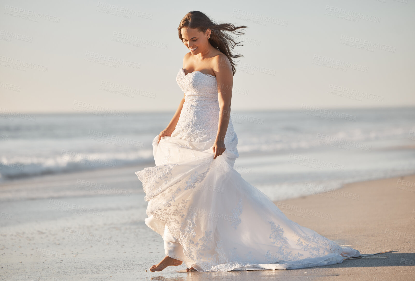 Buy stock photo Wedding, waves and a bride walking on beach in Australia on special day in summer. Happy barefoot woman in luxury designer dress, feet on sand, nature walk by ocean after marriage ceremony at the sea
