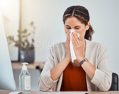 Covid, sick and woman blowing her nose with a tissue while working in her modern office during pandemic. Flu, cold or sinus allergy sneeze of girl from mexico sitting at her desk with health problems