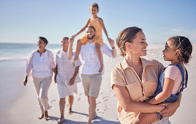 Buy stock photo Mother and child on holiday by the beach with grandparents taking a walk together. A happy big family walking by the sea and mom and dad carrying kids. Summer, vacation and family fun by the ocean