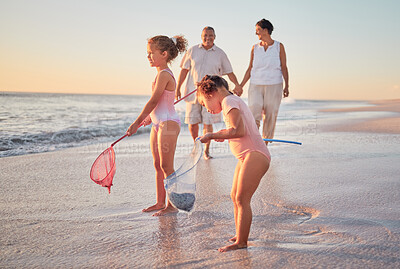 Buy stock photo Grandparents and children at the beach with fishing nets and having fun. Young kids and senior couple enjoying holiday with grandkids and retirement together. Playing by the sea in summer with family
