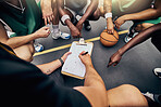 Basketball, sport and team with a sports coach talking to his team while planning tactics on a clipboard from above. Teamwork, fitness and exercise with a player and teammates listening at training