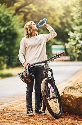 Buy stock photo Health, cycling and woman drinking water on a break in nature to hydrate, wellness and resting outdoors. Sports, exercise and thirsty biker riding bicycle by the road refreshing with liquid 