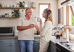 Elderly couple, coffee and kitchen smile, conversation and morning together in their home. Man, woman and retirement in house, happy and relax while talking at breakfast to start day or routine