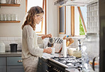 Mature woman pouring coffee in kitchen for drinking, breakfast and start relax morning at home in Australia. Happy lady enjoying mug of strong, hot and black espresso, tea and food in apartment house