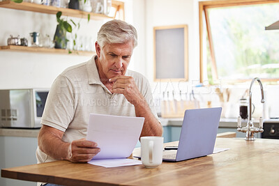 Buy stock photo Planning, documents and finance with elderly man on laptop in a kitchen, reading retirement and savings plan in his home. thinking, mortgage and investment paperwork with retired male contemplating  