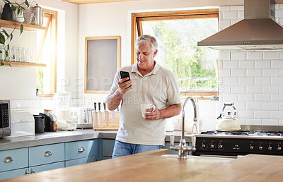 Buy stock photo Senior man, morning coffee and phone looking happy while reading text message, online news or browsing internet in kitchen at home. Male using messenger or social media mobile app in Australia house