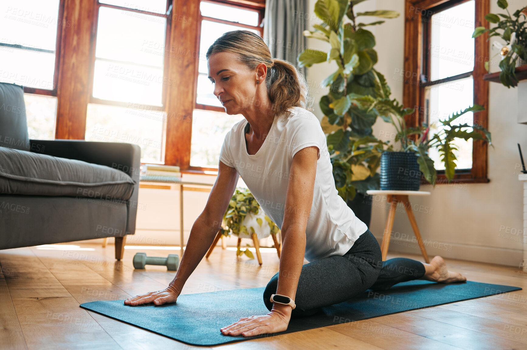 Buy stock photo Woman, yoga and pigeon pose stretching in house or home living room for relax exercise, training and workout in Germany lockdown. Zen, calm and mature peace yogi in mind wellness and fitness for hips