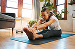 Senior woman, stretching and exercise in living room for fitness, cardio and wellness on yoga mat home training. Retirement, workout and healthy elderly retired person exercising legs on house floor