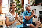 Meditation, wellness and yoga by elderly couple exercise and relax on a floor, bonding in a living room together. Zen, peace and fitness workout by mature man and woman exercising and doing cardio