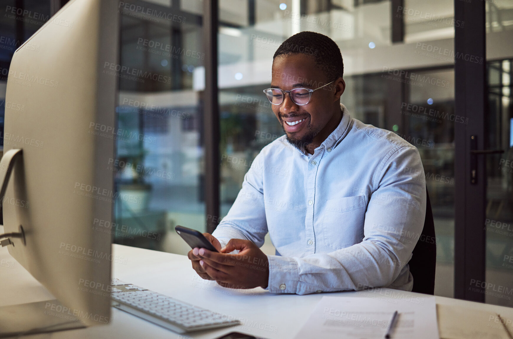 Buy stock photo Social media phone, night work and businessman reading an email on smartphone while working in a dark office at night. Corporate African manager in communication on mobile app while doing overtime