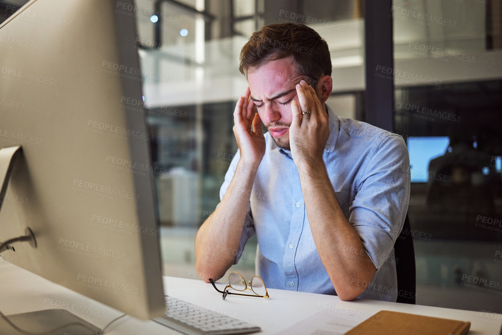 Buy stock photo Stress, depression and mental health for night business man sitting at his computer desk with headache, anxiety and burnout from work pressure. Stressed male working late in his Australia office