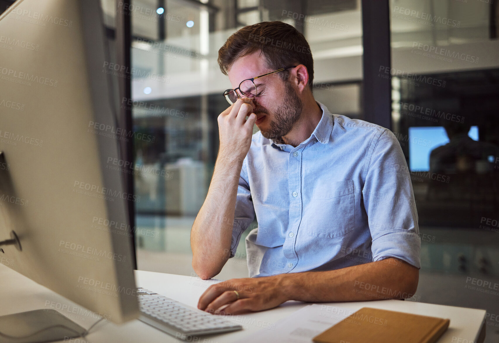 Buy stock photo Night business, stress and tired man sitting at his computer desk with headache, depression and burnout from work pressure. Stressed, mental health and depressed male working late in his office