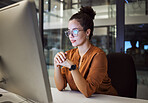 Night, research and report with a business woman working on a computer in her startup office at night. Thinking, idea and technology with a young female entrepreneur at work on a desktop in a company