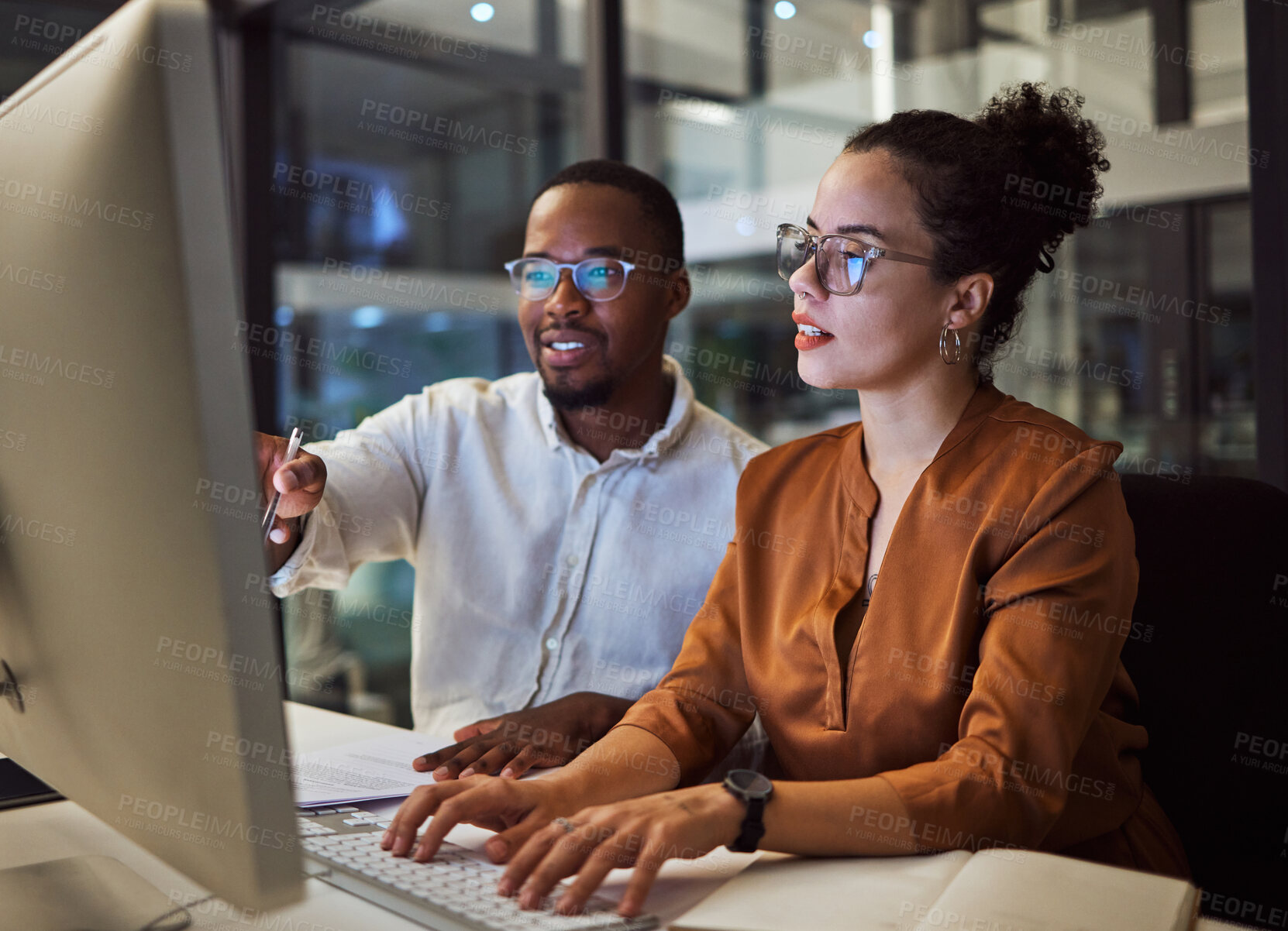 Buy stock photo Night training, teamwork and employees planning marketing strategy in a dark office on computer at work. Corporate African man and woman talking about business collaboration during overtime together