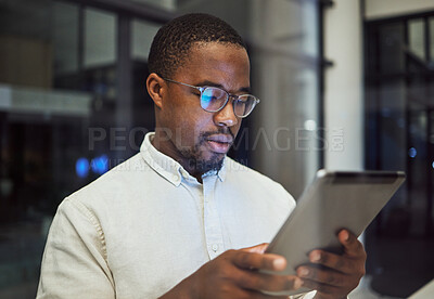 Buy stock photo Tablet research, night planning and businessman working on email on the internet while in a dark office at work. Corporate African employee reading communication online on tech while doing overtime